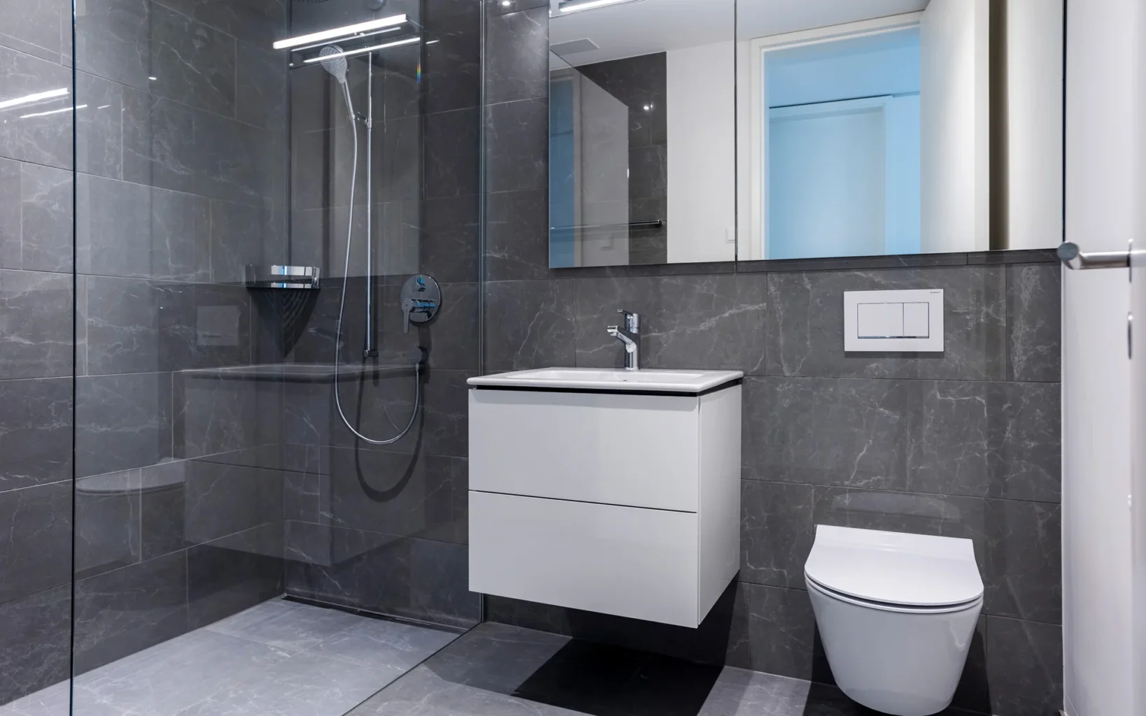 Modernes Badezimmer mit Glasduschkabine und weißer Einrichtung