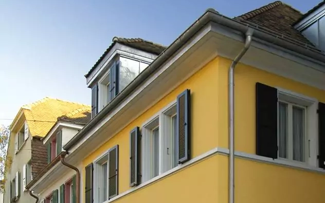 Gelbes Haus mit dunklen Klappläden