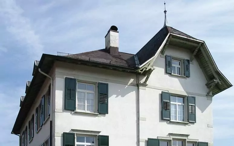 Altes haus mit Giebeln und dunkelgrünen Klappfensterläden