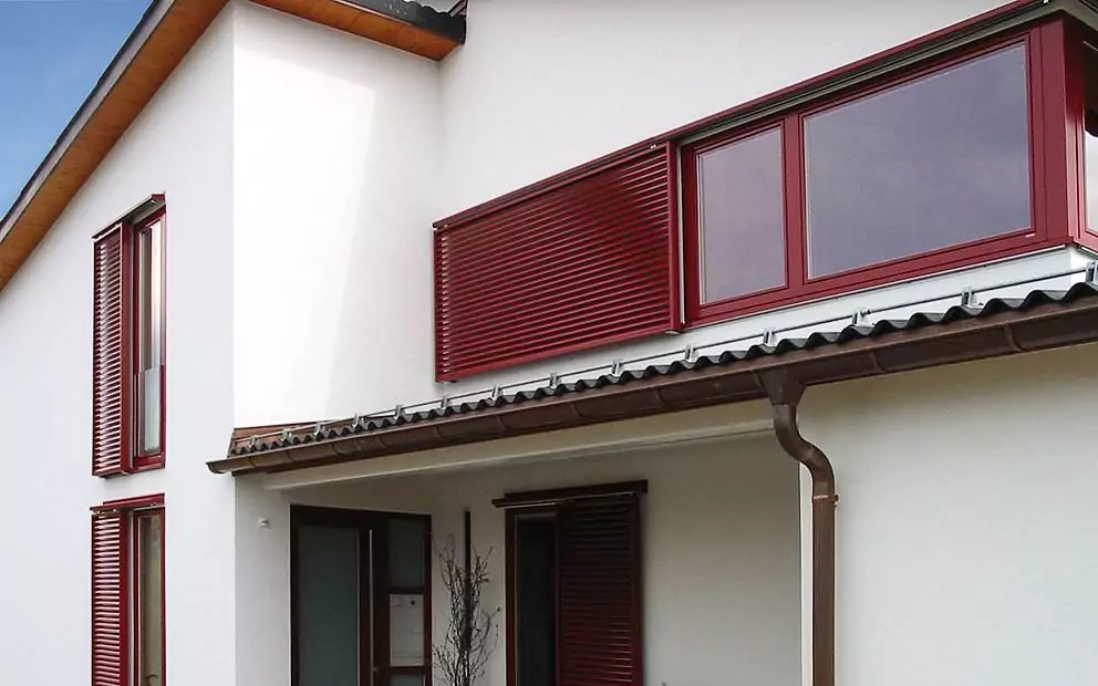 Modernes Haus mit roten Schiebeläden in verschiedenen Formaten