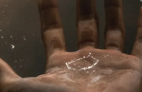 Hand mit Regentropfen, die hineinplatschen