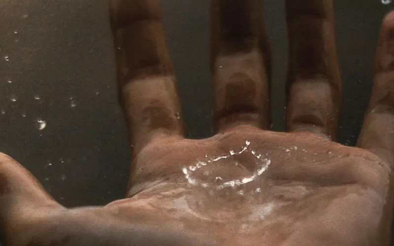 Hand mit Regentropfen, die hineinplatschen